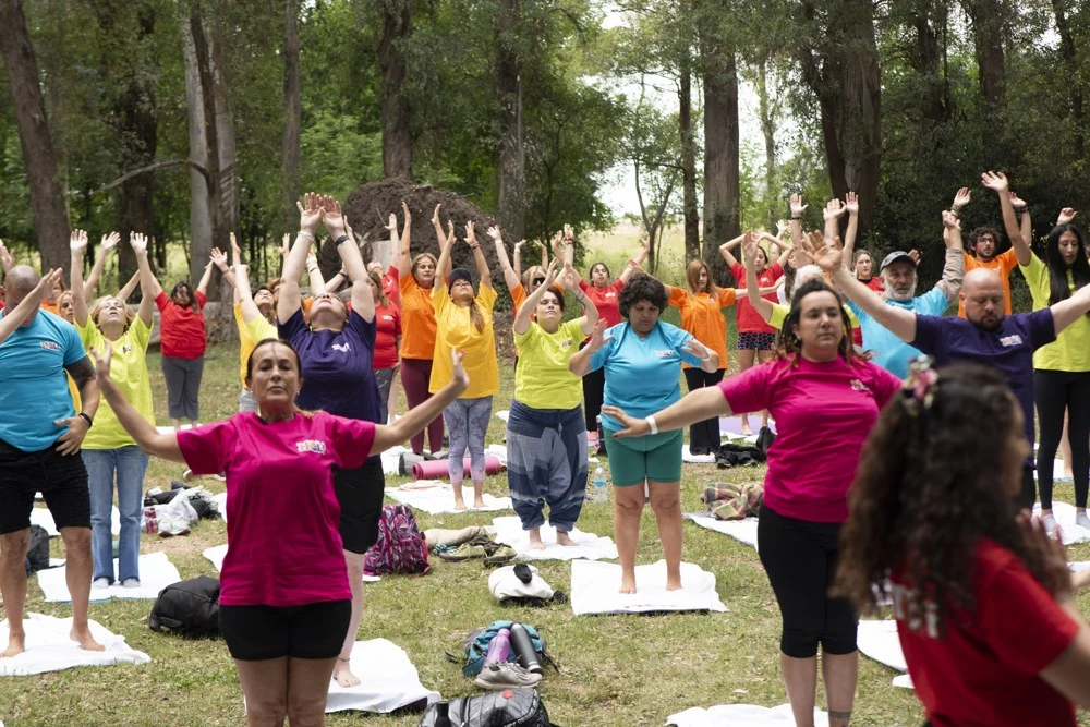 Yoga en comunidad bajo los árboles en Holi 2024