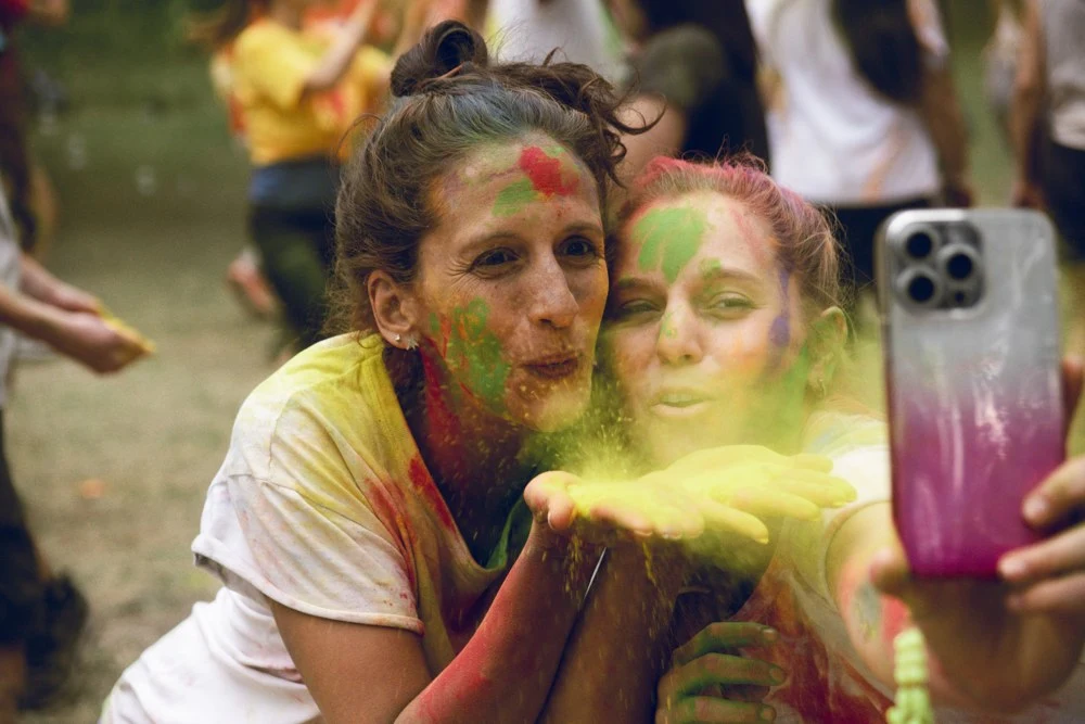 Amigas compartiendo polvos de colores en Holi 2024